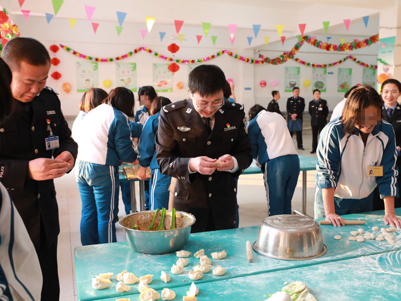 （用）省司法厅戒毒管理局局长段剑平（中）同干警、戒毒学员一起包饺子。