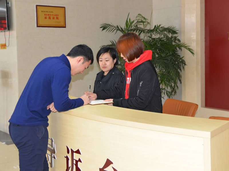 图二，记者和导诉台工作人员一起指引市民查询信息