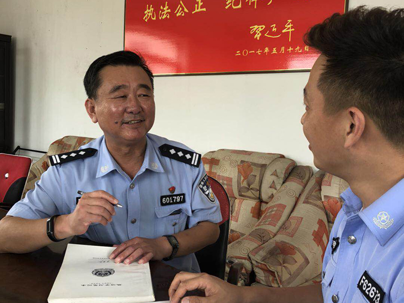 张殿宽（左）与民警研究工作