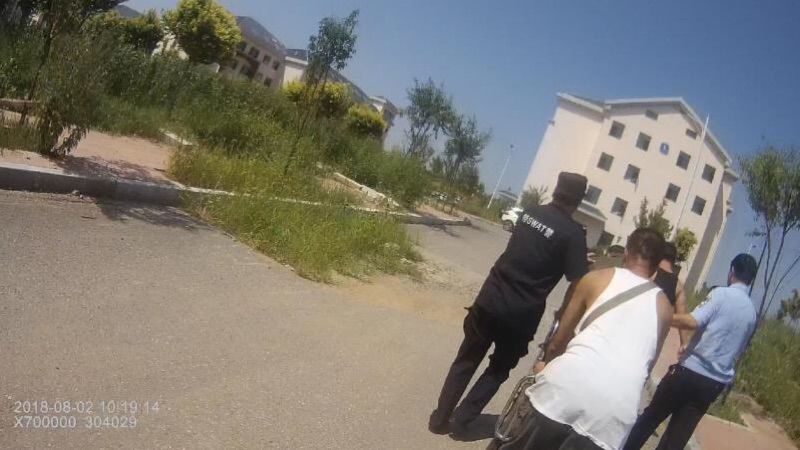 民警和家属将发病持刀男子送往医院治疗