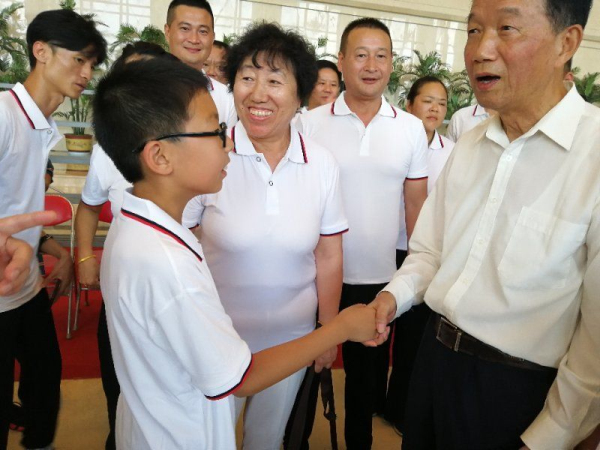 贾春旺理事长同石树曾的外孙握手_编辑