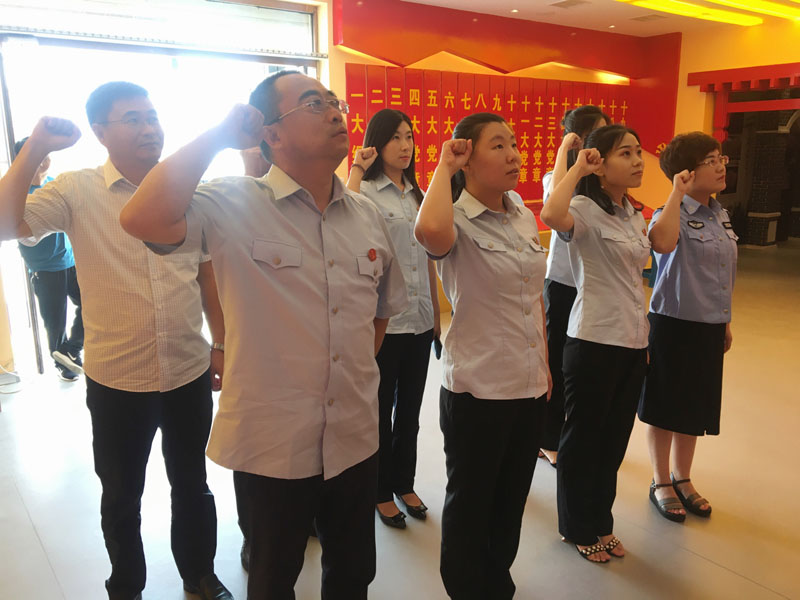 大洼法院干警面对党旗进行重温入党誓词活动。