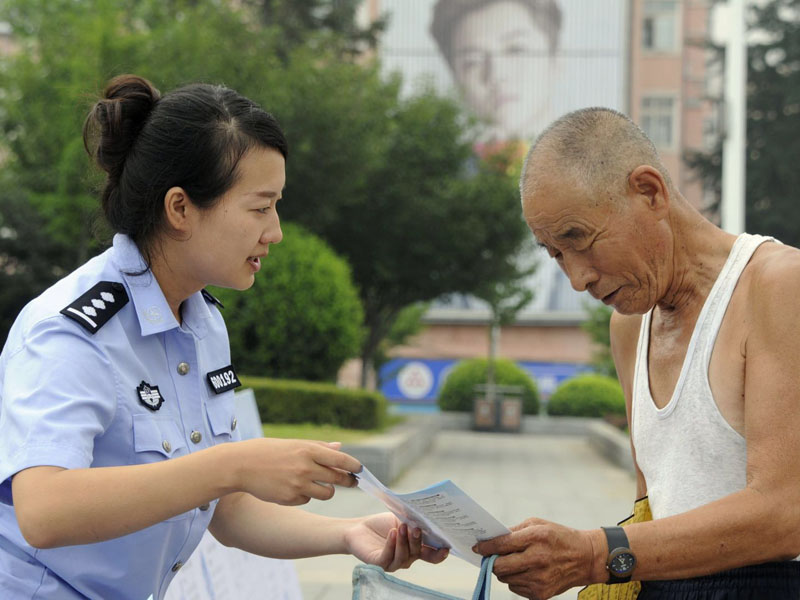 民警向市民发放扫黑除恶宣传单