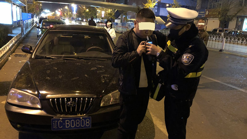 李某被拦停后接受酒精测试（车牌为伪造）