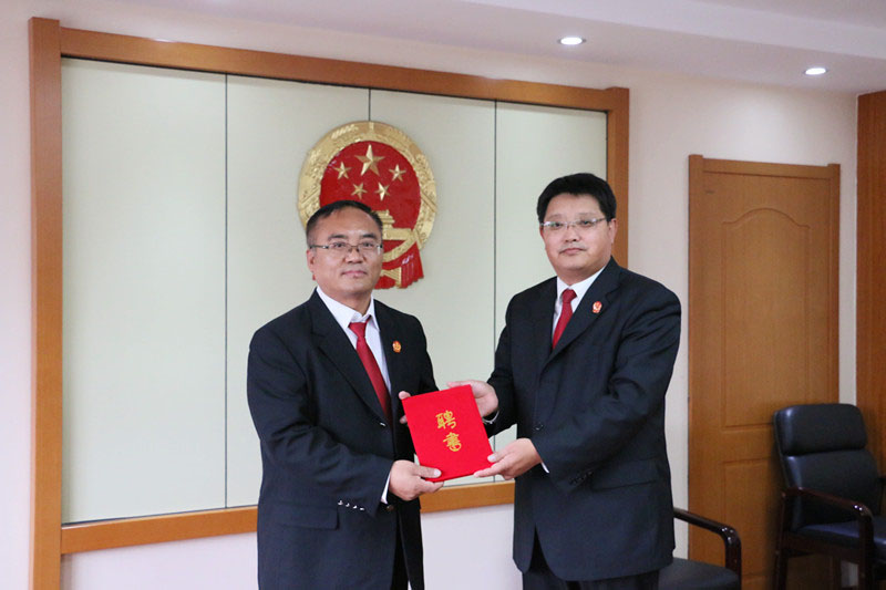 锦州市太和区人民法院党组书记、院长康赢健(右)为新任法官导师颁发了聘书