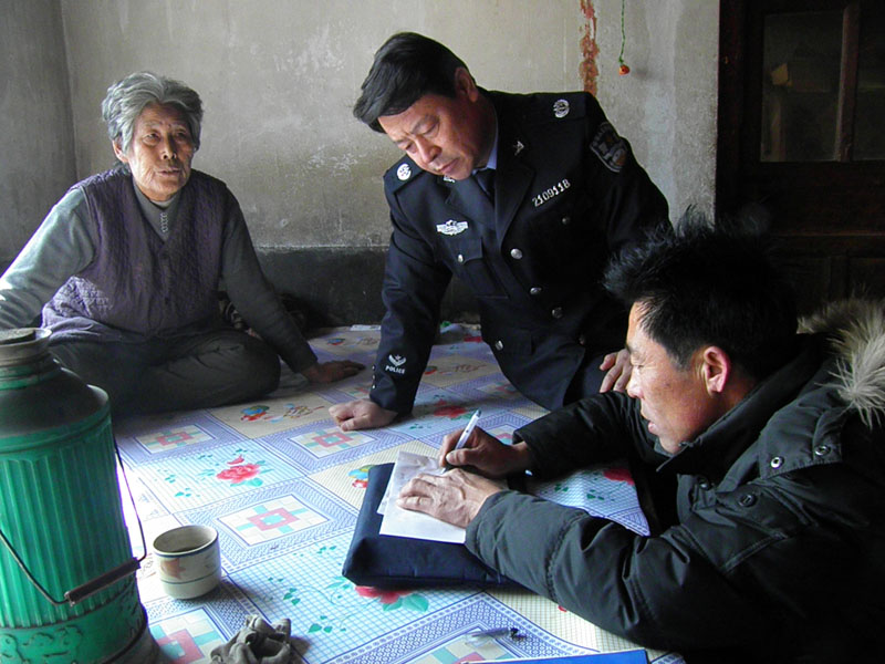 阜蒙县司法局副局长张彪(中）在受助村民家中走访