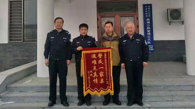 王某（左三）将锦旗送到民警手中