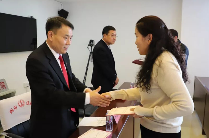 吴恩成（左）向新任人民陪审员颁发证书
