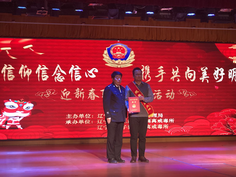 省司法厅副厅长椰永涛（左）为宋晓颁发聘书，佩戴戒毒公益大使绶带