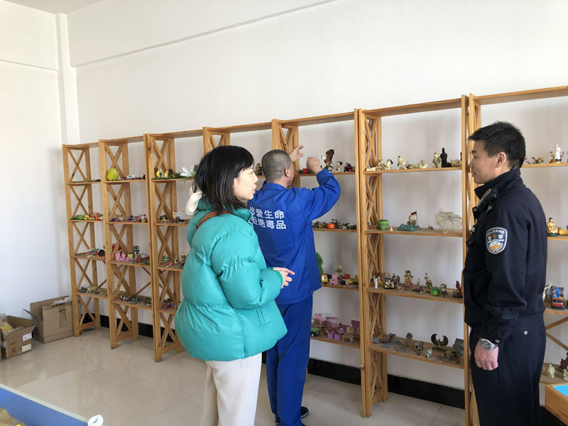 记者（左）与戒毒干警张鹏在沙盘治疗室陪同戒毒学员张某选择沙盘物品