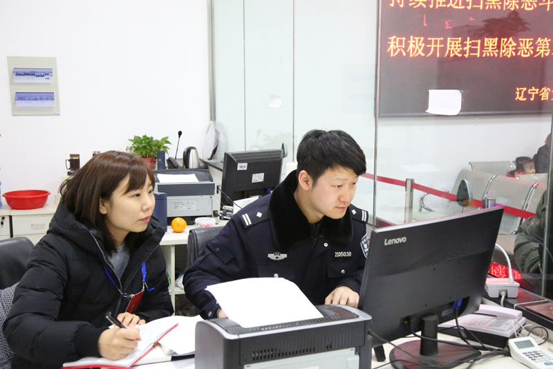 记者（左）与干警赵维佳一起为服刑人员亲属办理会见登记