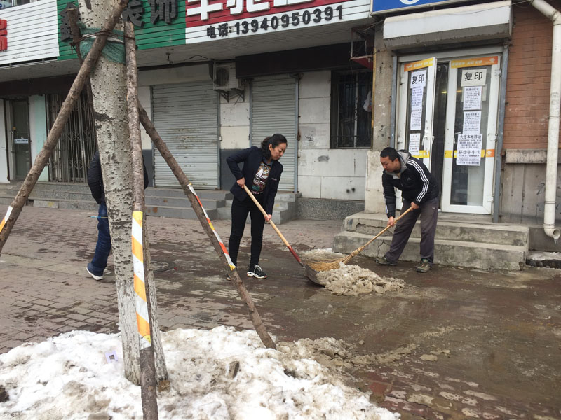 记者和网格员清理积冰