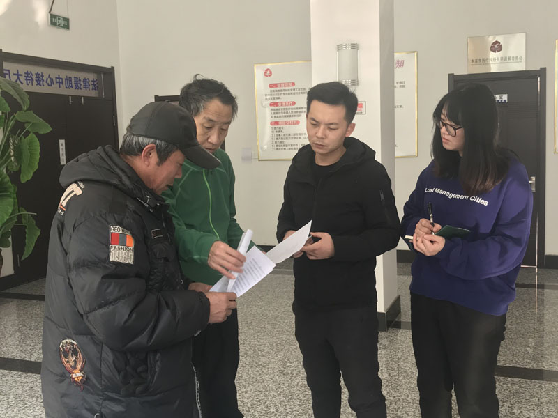 记者（右一）同中心工作人员为来申请法律援助的市民进行服务