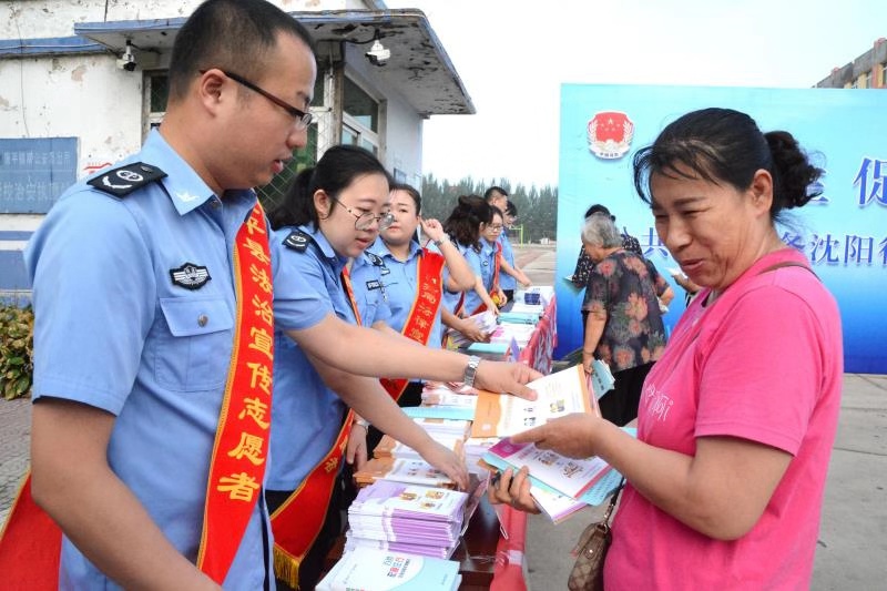 法治宣传志愿者向市民发放宣传手册