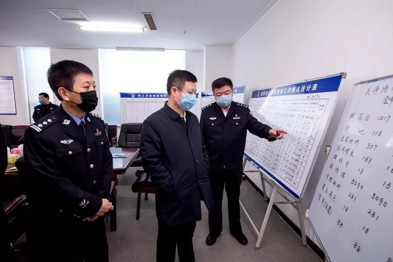孟翔飞（中）与李云波（右一）在铁岭公安局疫情防控指挥部查看挂图作战表