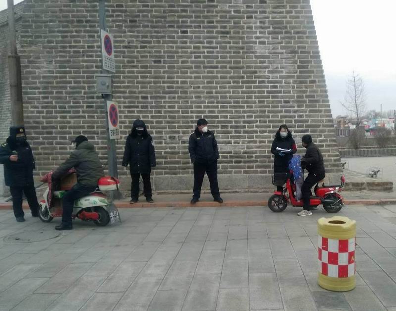 李红立在古城下劝阻居民（右二）