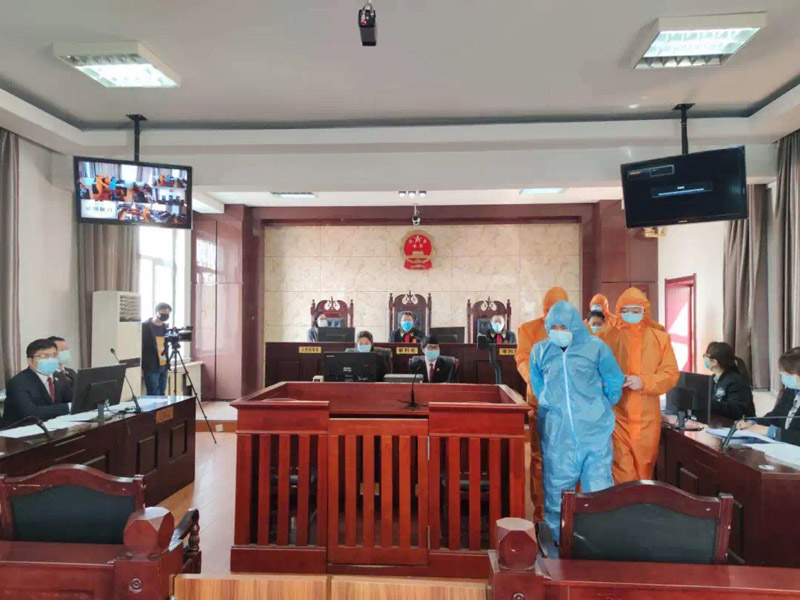 被告人吕某穿防护服受审