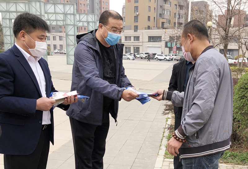 范静波（中）在发放扫黑除恶宣传手册