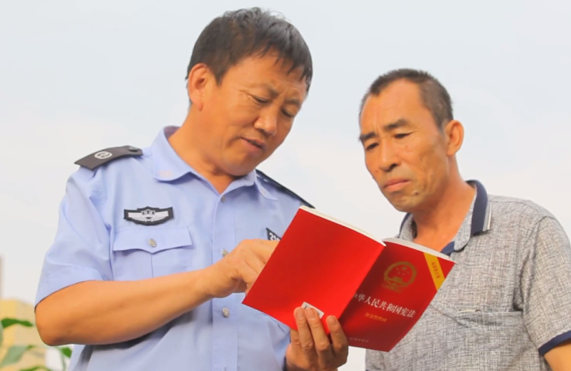 配文2：徐富权（左）在为村民普及法律知识