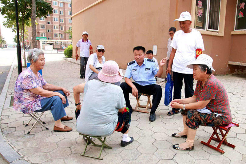 李化瑞和辖区群众聊家常，听取他们对小区平安建设的意见和建议。