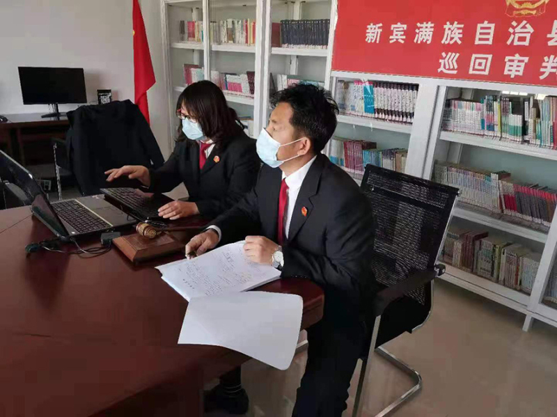 法官孙锡铭（右）与法官助理正在开展巡回审判