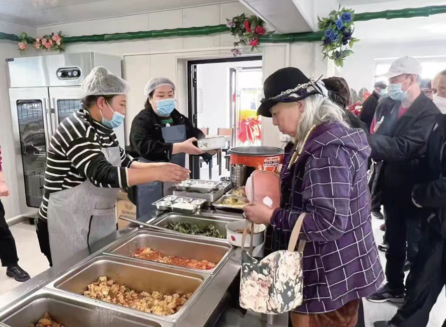 配文1：社区居民在食堂打饭。
