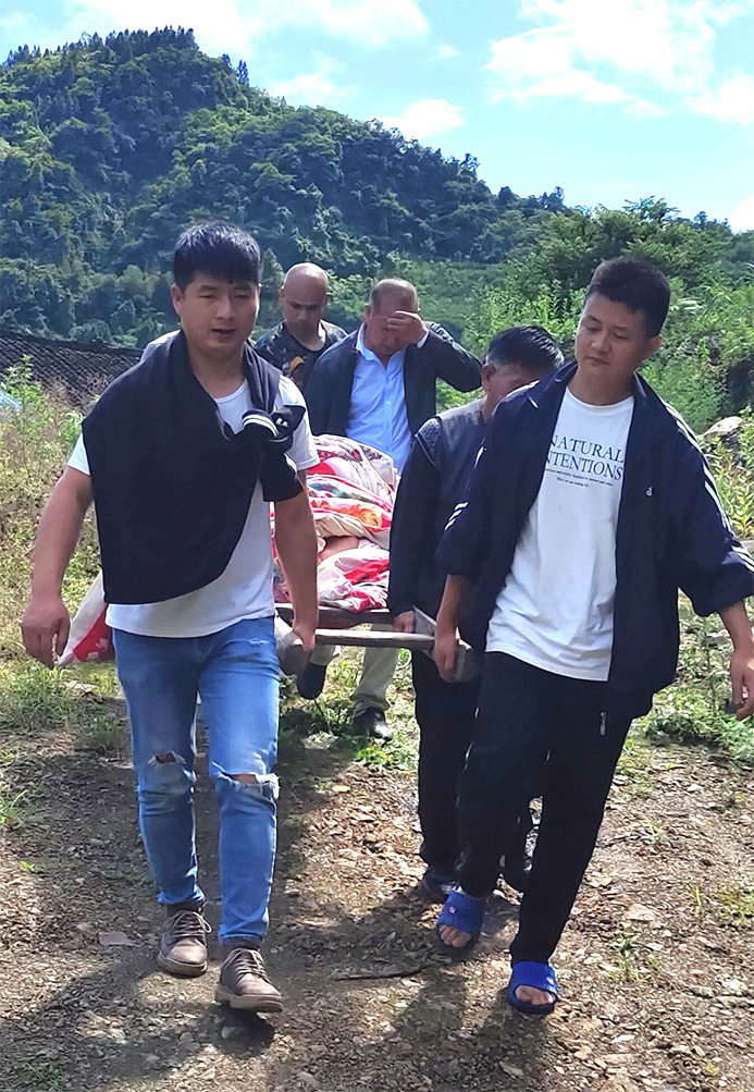 山高路远，清水坪镇网格员抬着担架送患病的老人去医院治病