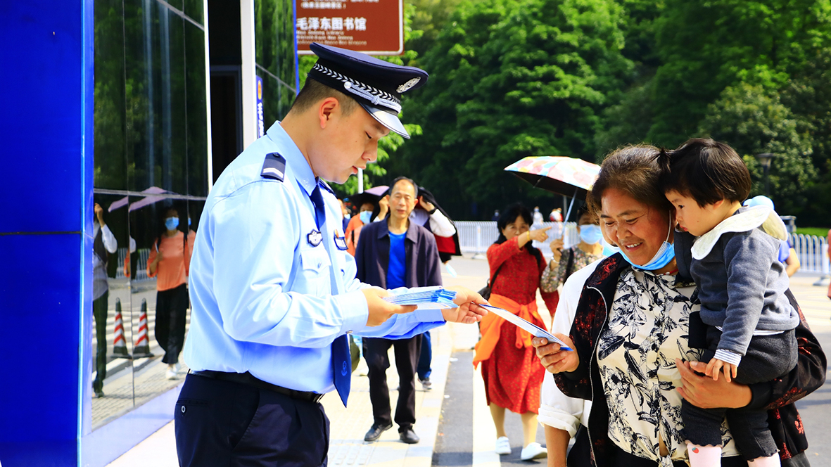 韶山冲派出所，民警向游客发放反诈宣传单
