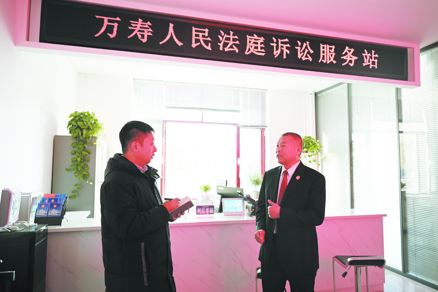 （法庭故事）张振东（右）向记者介绍工作情况