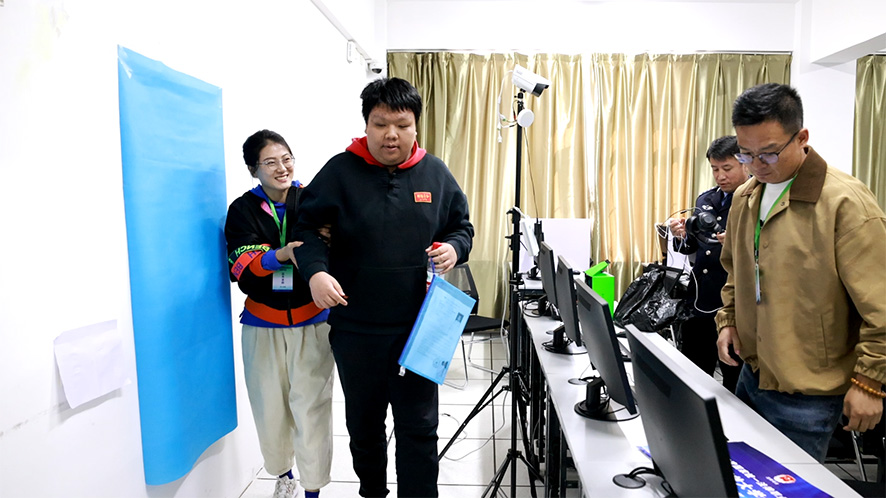 辽宁开放大学考区考务人员帮助盲人考生参加考试。