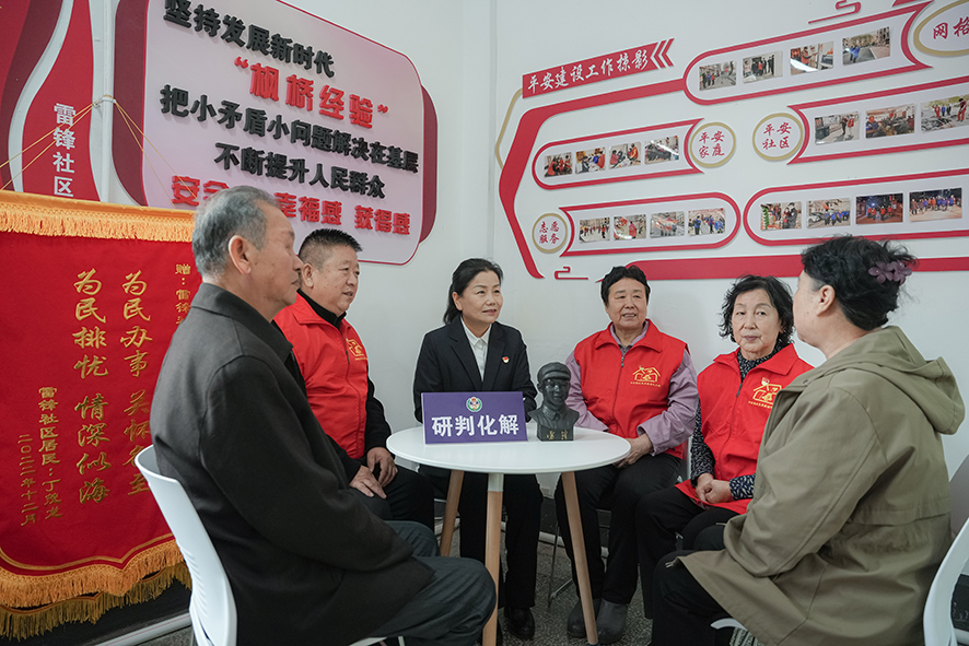 吴振华（左三）组织代办员在党员代办站进行工作交流