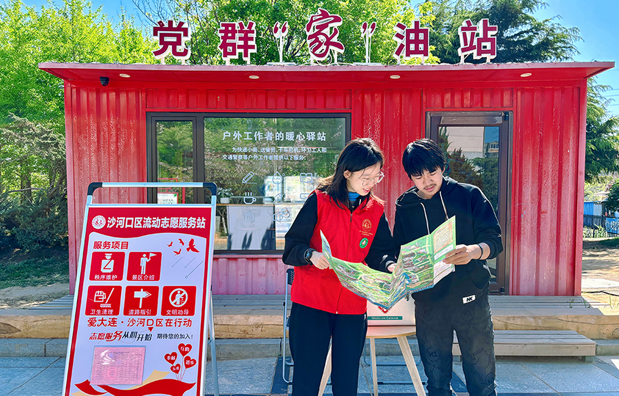 （头题配图）志愿者在大连沙河口区流动志愿服务站服务游客