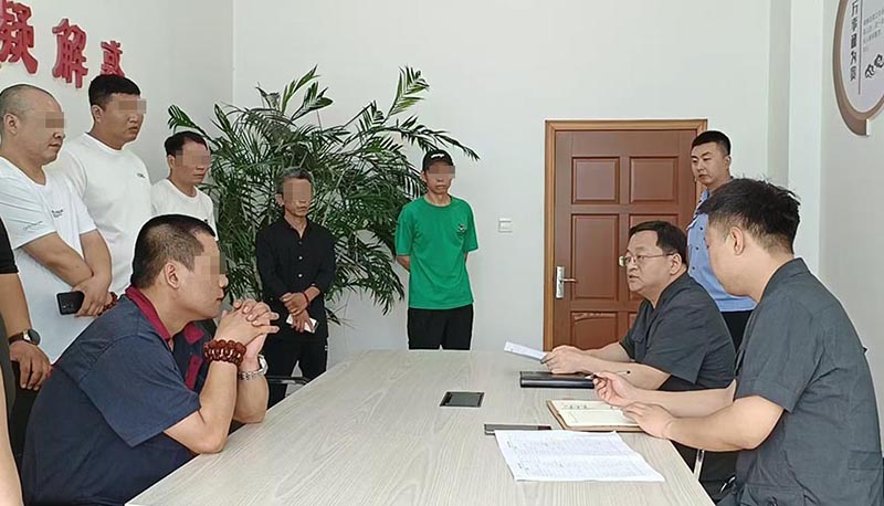 新民市法院执行局局长王旌棘（右3）向农民工们了解案情（所有不穿法服和警服的人，都需要马赛克!）