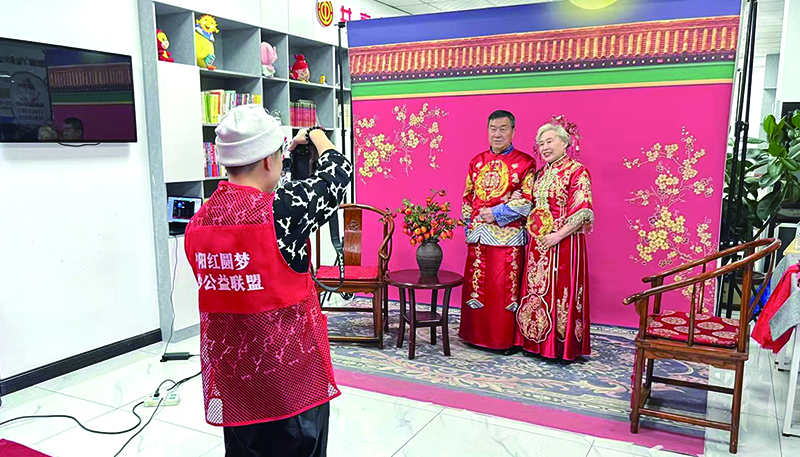 摄影师为一对老年夫妇拍摄中式婚纱照