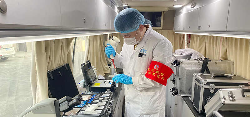 （二题配图）工作人员现场对抽样进行检测