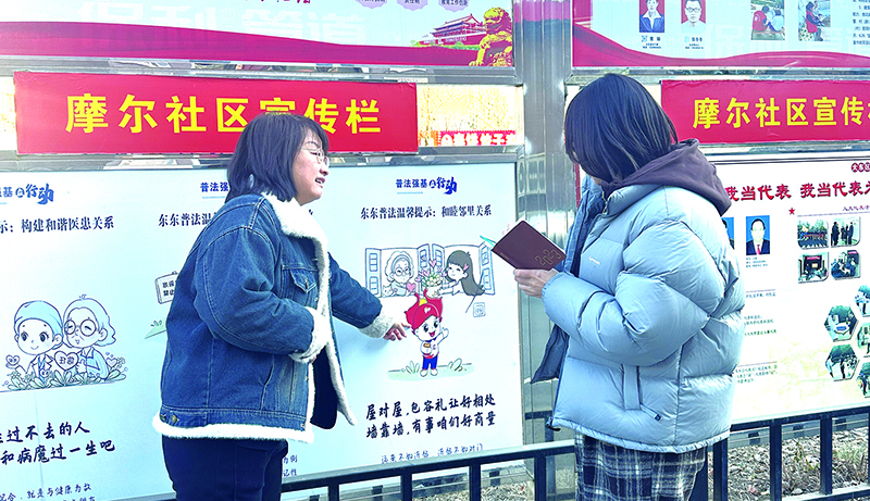 薛娜向记者介绍法治漫画普法宣传栏 孟浩摄