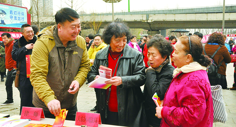 张京涛（左）到街头开展普法宣传活动