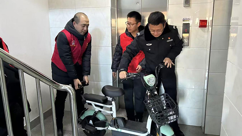 志愿者与民警一起讲电动自行车从楼道清除