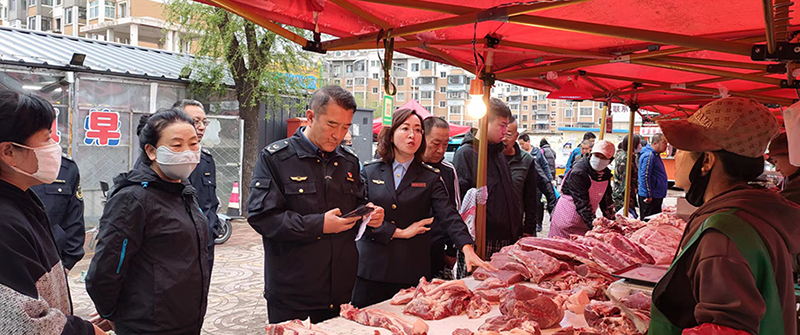 阜新：图为执法人员对菜市场一肉类产品进行专项检查。