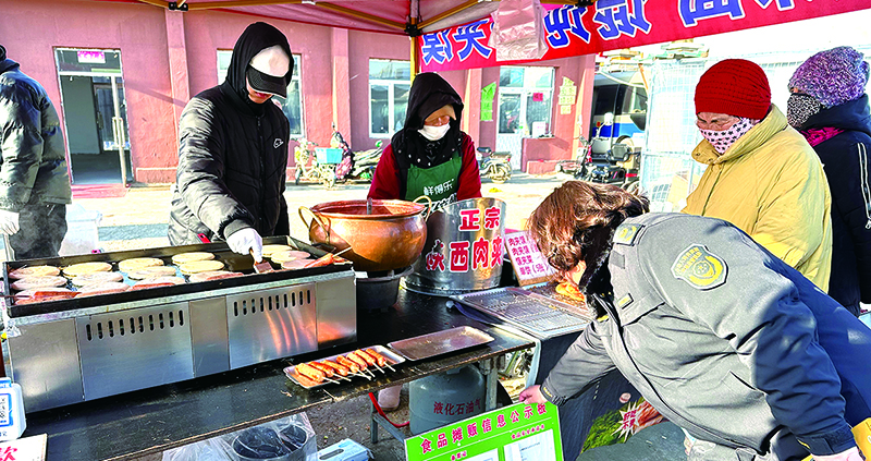 市场监管工作人员查看食品摊贩信息