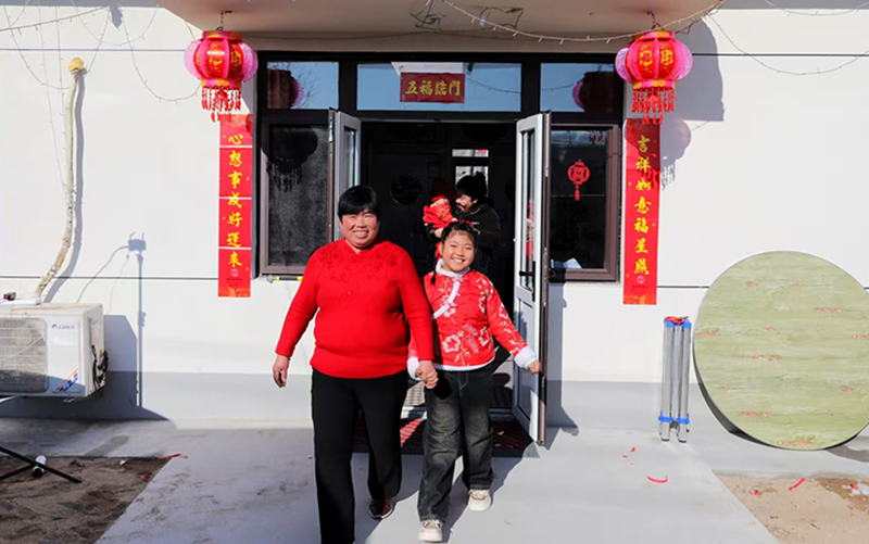 绥中县明水满族乡祝家沟村村民在新房前