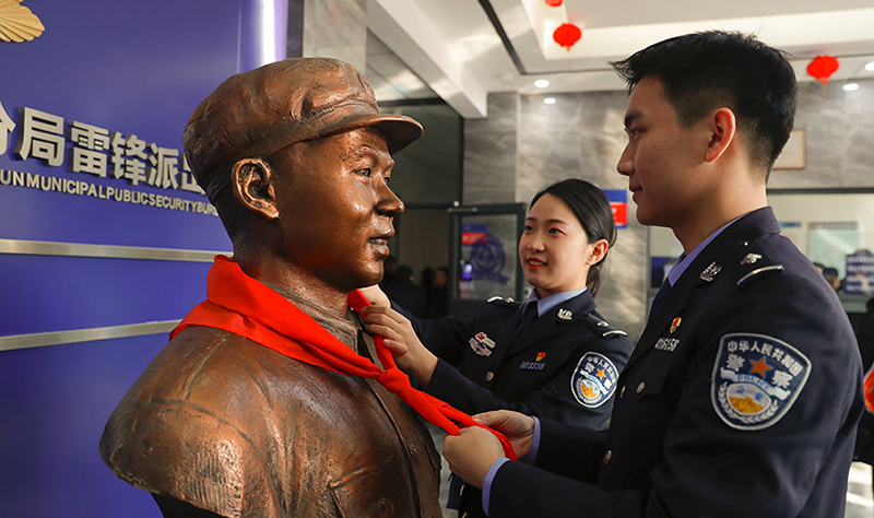 2024年3月5日，抚顺市公安局望花分局雷锋派出所民警白静（右）和长沙市公安局雷锋派出所民警韩政霖（左）共同为雷锋塑像整理红领巾。