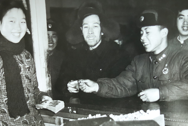 1950年，在梁金英（左一）的见证下，雷锋（右二）向和平公社捐款100元现金