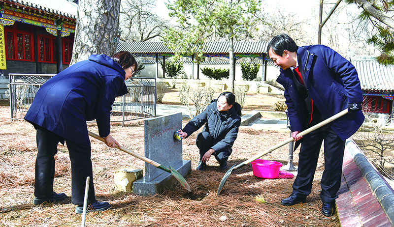庭长贾宏斌（右一）、副庭长史致鹤（左一）、法官助理李元旬为古树填土浇水