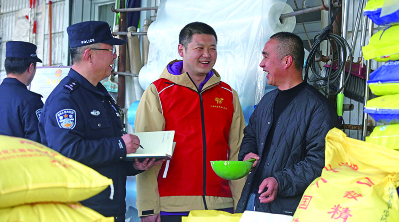二题图：在一家农药化肥经销店,民警向店主提示,农忙时电信诈骗多,要注意防范电信诈骗,同时不要经营伪劣农药化肥。