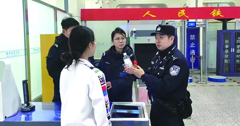 二题图，童秋华（右）在向旅客讲解安检规定