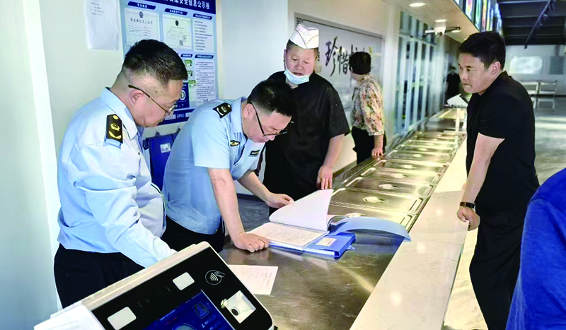 执法人员在学校食堂后厨检查食材进货渠道