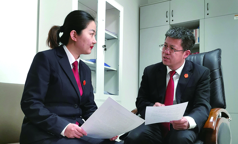 省法院民事审判第三庭庭长董凯（右）就结项论文内容对杨蒙进行指导
