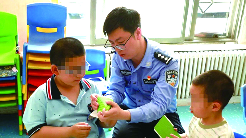 二题图，民警在营口市金石自闭症儿童幼儿园指导孩子制作粽子折纸