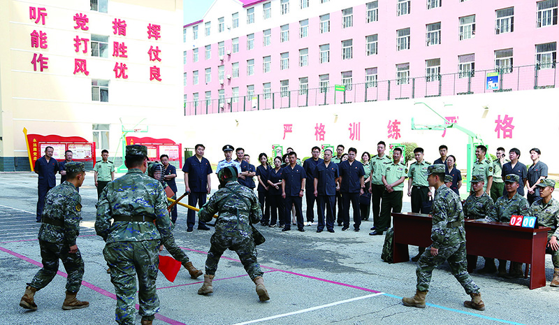 法院干警在训练场上观看武警官兵军事科目训练